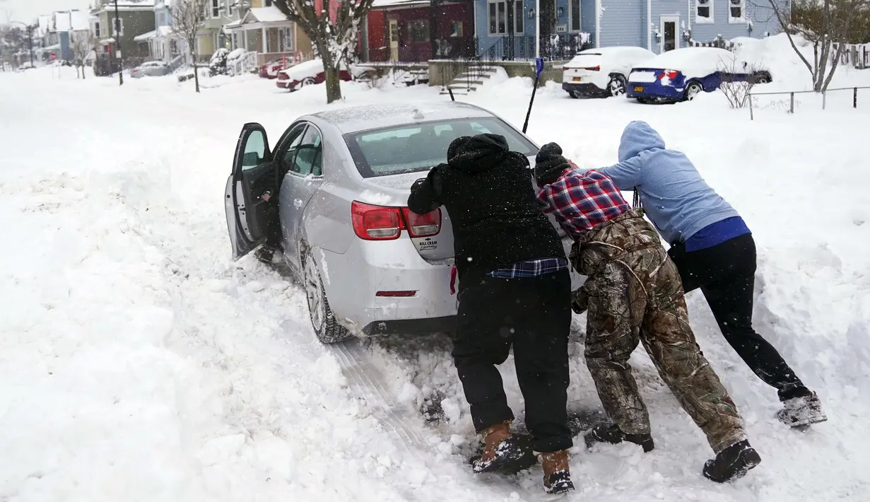 Tetangga membantu mendorong pengendara yang terjebak salju di Buffalo, New York, Amerika Serikat, 26 Desember 2022. Korban tewas diperkirakan dapat bertambah. (Derek Gee/The Buffalo News via AP)