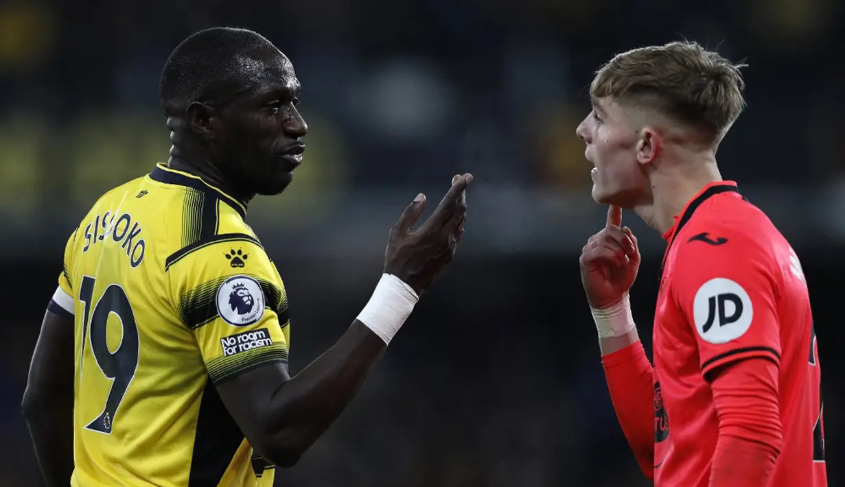 Pemain Watford Moussa Sissoko (kiri) dan pemain Norwich City Brandon Williams adu argumen pada pertandingan sepak bola Liga Inggris di Vicarage Road Stadium, Watford, Inggris, Sabtu (22/1/2022). Norwich City menang 3-0. (Adrian DENNIS/AFP)