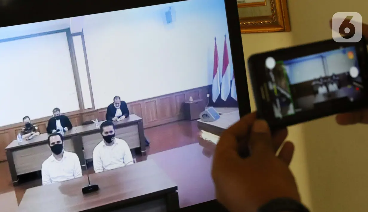 Pewarta merekam layar monitor yang menampilkan dua terdakwa penyiraman air keras terhadap penyidik KPK Novel Baswedan, Rahmat Kadir Mahulette (kanan) dan Rony Bugis yang mengikuti sidang putusan secara teleconference di PN Jakarta Utara, Kamis (16/7/2020). (Liputan6.com/Helmi Fithriansyah)