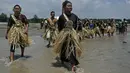 Penduduk dari Suku Mah Meri berjalan menuju laut selama ritual Puja Pantai di Pulau Carey, Kuala Lumpur, 9 Februari 2019. Puja Pantai merupakan ritual persembahan kepada roh laut yang digelar untuk merayakan tahun baru Suku Mah Meri. (Mohd RASFAN/AFP)