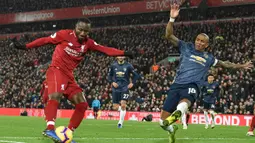 Gelandang Manchester United, Ashley Young, menghalau umpan gelandang Liverpool, Naby Keita, pada laga Premier League di Stadion Anfield, Liverpool, Minggu (16/12). Liverpool menang 3-1 atas MU. (AFP/Paul Ellis)