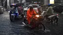 Pengendara berkendara melalui jalan yang banjir saat hujan deras di Bangkok (23/9/2020). (AFP/Mladen Antonov)