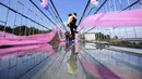 Sepasang pria dan wanita berciuman diatas sebuah jembatan kaca saat mengikuti kontes berciuman di Hari Valentine di Pingjiang, Provinsi Hunan, China (14/2). (STR / AFP)