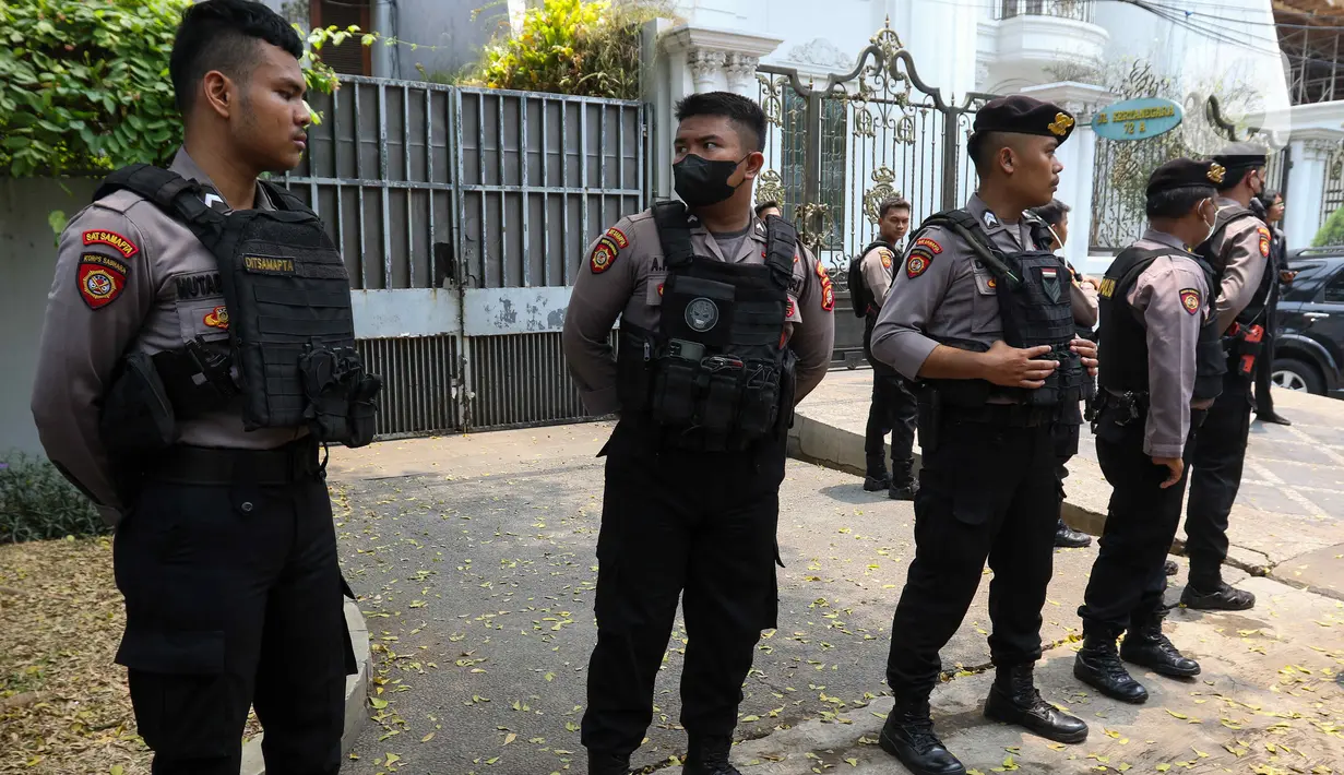 Aparat kepolisian dengan seragam lengkap serta rompi dan senapan berjaga-jaga di depan rumah. (Liputan6.com/Herman Zakharia)