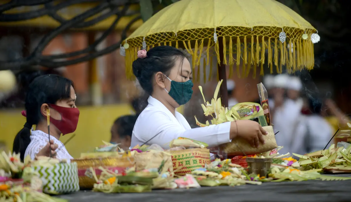 Seorang wanita bersiap berdoa untuk merayakan festival keagamaan Galungan di Pura Jagat Natha di Denpasar, di pulau Bali (16/9/2020). Galungan dirayakan umat Hindu di Bali sebagai hari kemenangan Dharma (Kebaikan) melawan Adharma (Keburukan). (AFP Photo/Sonny Tumbelaka)