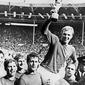 Kapten Timnas Inggris, Bobby Moore, mengangkat trofi Piala Dunia 1966. (AFP)