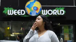 Pelanggan mengisap ganja yang dijual bebas di toko Weed World di New York (31/3/2021). Pengesahan tersebut dibuat setelah Gubernur New York Andrew Cuomo menandatangani undang-undang yang melegalkan ganja pada 31 Maret 2021. (AFP/Kena Betancur)