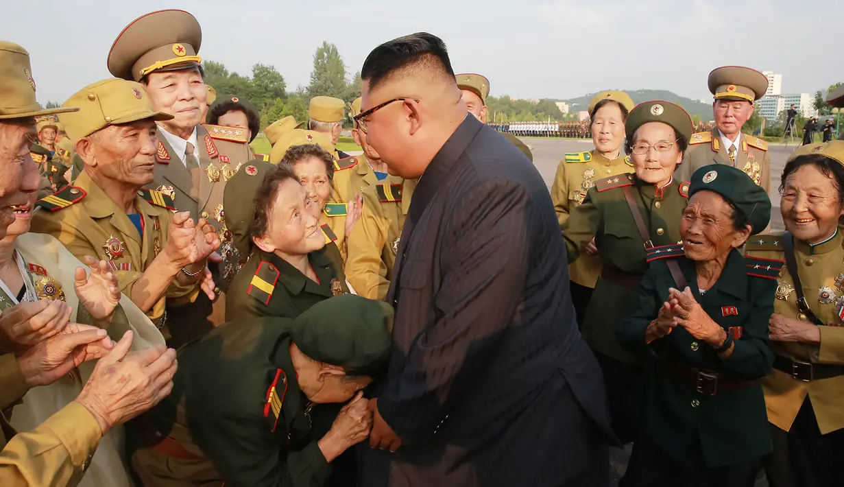 Seorang veteran perang wanita mencium tangan Pemimpin Korea Utara Kim Jong-un selama acara Konferensi Veteran Perang Nasional ke-5 di pemakaman perang Martyrs Cemetery di Pyongyang (27/7). (KCNA/via AP Photo)