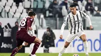 Bintang Juventus Cristiano Ronaldo mencoba melewati pemain Torino Romas Rincon pada pekan ke-10 Liga Italia di Allianz Stadium, Minggu (6/12/2020) dini hari WIB. (Marco Alpozzi/LaPresse via AP)