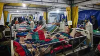 Para korban gempa bumi mendapatkan perawatan di tenda medis darurat di depan Rumah Sakit Ruteng di Ruteng, Manggarai, Nusa Tenggara Timur, Sabtu malam, 15 Agustus 2025. (AFP/ Juni Kriswanto)