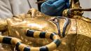 Arkeolog merestorasi sarkofagus atau peti mati emas Firaun Tutankhamun di laboratorium restorasi Grand Egyptian Museum (GEM), Giza, Mesir, Senin (13/4/2020). Firaun Tutankhamun merupakan Raja Mesir Kuno yang memerintah antara tahun 1342-1325 SM. (Khaled DESOUKI AFP)