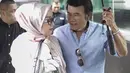Rhoma Irama memayungi istrinya Ricca Rachim saat hadir dalam konferensi pers indosiar Ramadhan Penuh Berkah di Jakarta, Kamis (26/4). (Liputan6.com/Faizal Fanani)