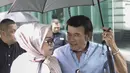 Rhoma Irama memayungi istrinya Ricca Rachim saat hadir dalam konferensi pers indosiar Ramadhan Penuh Berkah di Jakarta, Kamis (26/4). (Liputan6.com/Faizal Fanani)