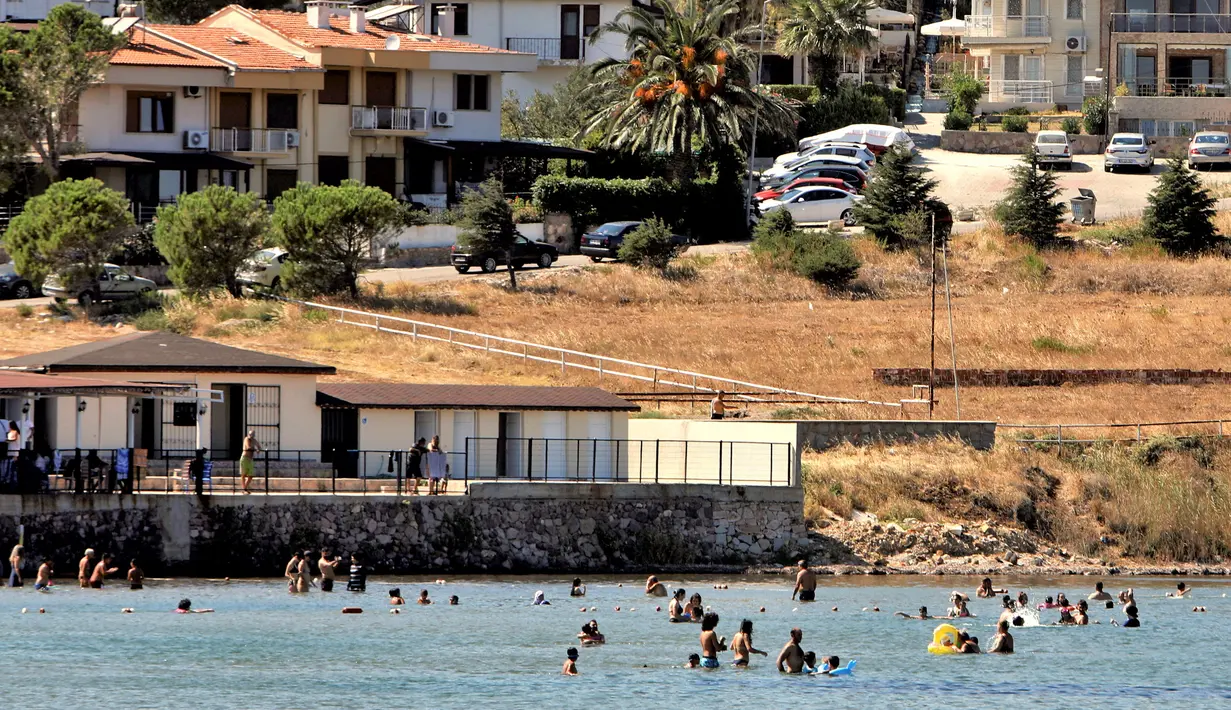Warga berlibur di sebuah pantai di Distrik Ayvalik, Provinsi Balikesir, Turki, 4 Agustus 2020. Ramainya kunjungan warga Turki ke pantai-pantai selama liburan empat hari Idul Adha pekan lalu memicu kekhawatiran merebaknya kembali pandemi COVID-19 di negara itu. (Xinhua/Osman Orsal)