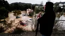 Seorang pria mengamati beberapa mobil yang tersapu air di kota Alora, Malaga, Spanyol, Selasa, 29 Oktober 2024. (AP Photo/Gregorio Marrero)