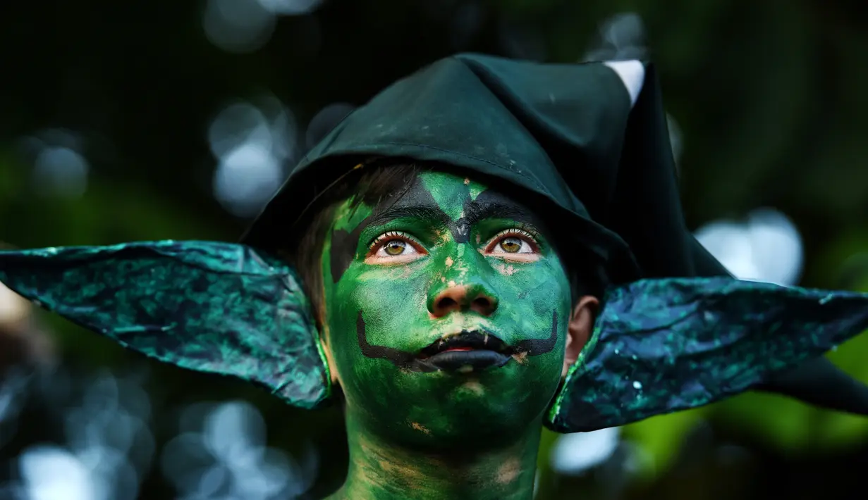 Peserta mewarnai badannya selama mengikuti parade " La Calabiuza " di El Savador, Minggu (1/11/2015). Selama perayaan, warga Tonacatepeque memakai kostum karakter dari mitologi Cuscatlan. (AFP PHOTO/Marvin RECINOS)