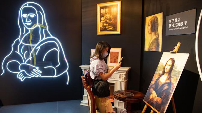 Seorang pengunjung mengabadikan gambar dalam sebuah pameran seni bertajuk Tribute to da Vinci yang digelar di gedung Changsha IFS, Changsha, Provinsi Hunan, China, Senin (4/5/2020). (Xinhua/Chen Sihan)