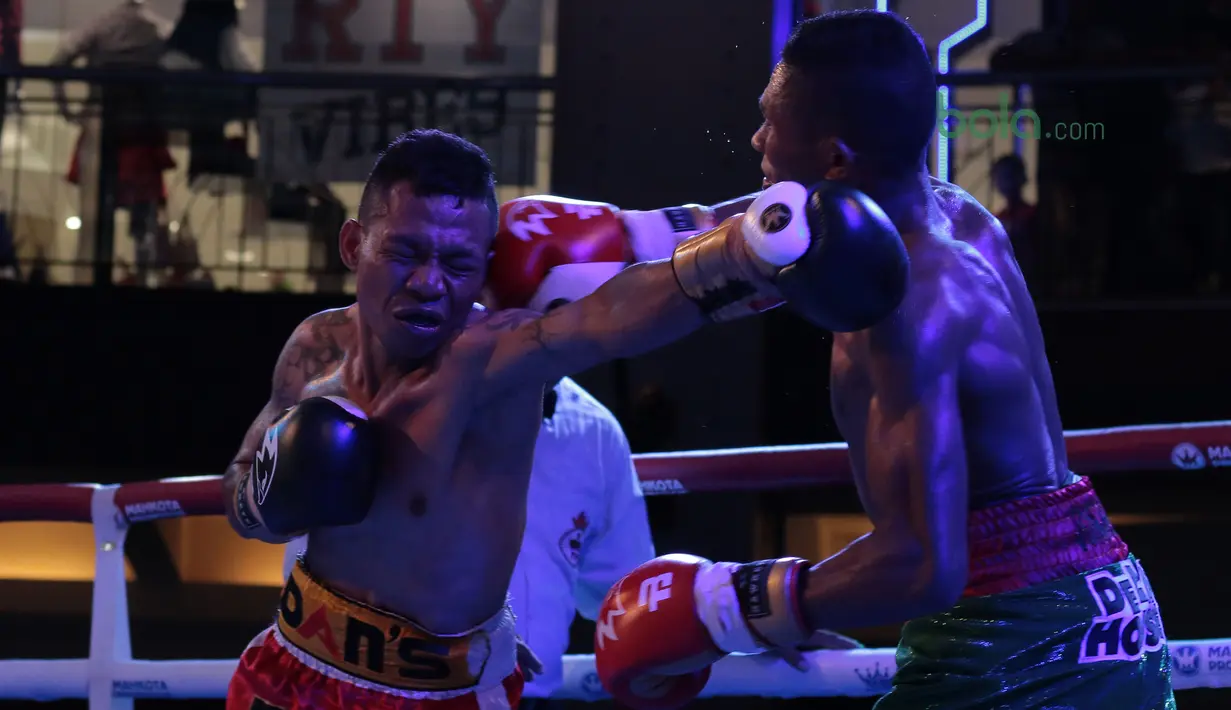 Frans Damur (kiri) dan Jon Jon Jet saling melepaskan pukulan pada kelas Flyweight Mahkota Boxing Super Series di Cilandak Town Square, Jakarta (10/3/2018). Jon Jon Jetz menang angka mutalak atas Frans. (Bola.com/Nick Hanoatubun)