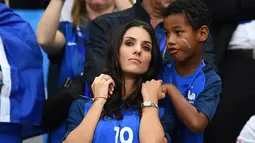 Istri bek Prancis Bacary Sagna, Ludivine Sagan datang bersama buah hatinya menyaksikan sang suami berjuang bersama timnas Prancis melawan Rumania di Stade de France, Saint-Denis, Paris, (10/6). (AFP PHOTO/FRANCK FIFE)