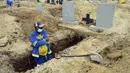Seorang penggali makam menyiapkan kuburan baru di Pemakaman Motherwell di Port Elizabeth, Afrika Selatan pada 4 Desember 2020. Menteri Kesehatan Afrika Selatan, Zweli Mkhize pada Rabu (9/12/2020) mengumumkan negara itu sekarang sedang mengalami gelombang kedua Covid-19. (AP Photo/Theo Jeftha)