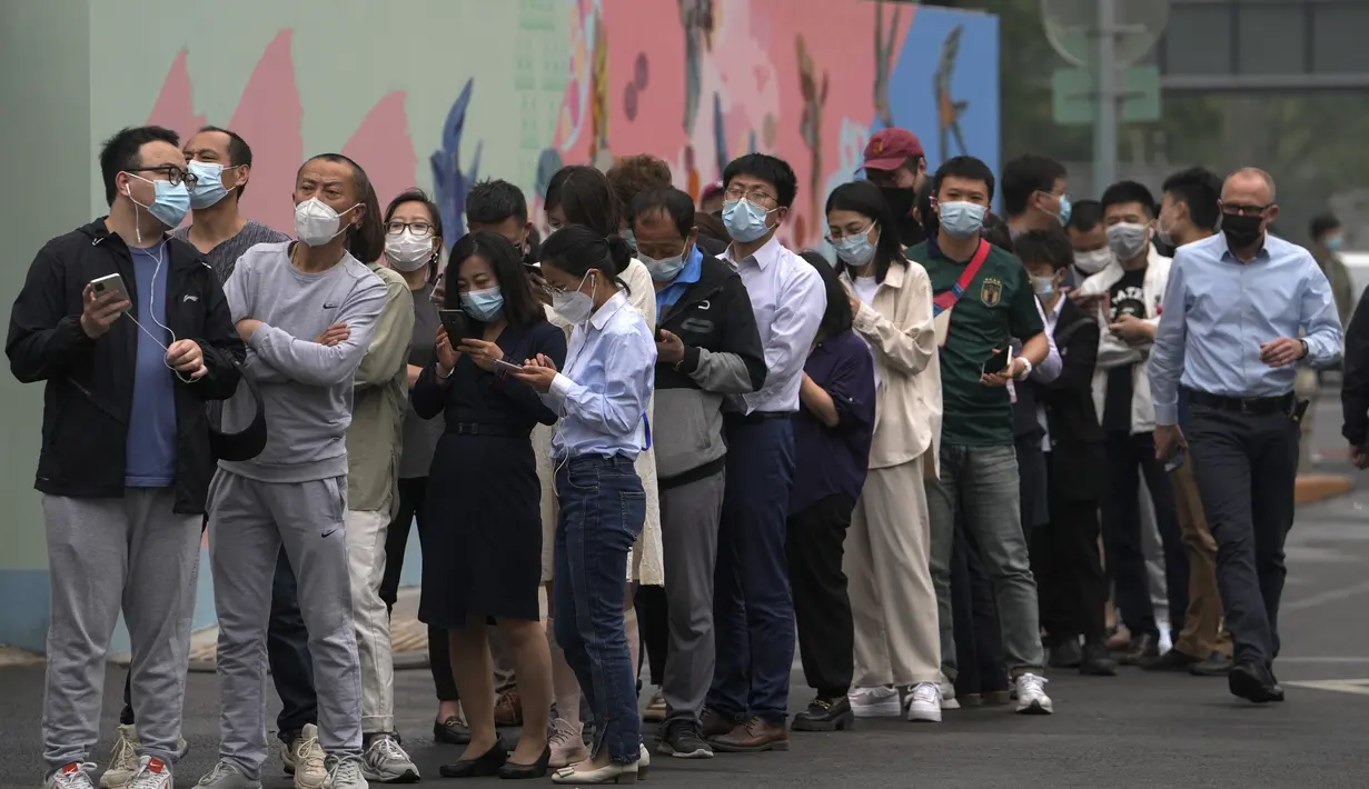 <p>Warga dan pekerja kantoran yang mengenakan masker berbaris untuk tes COVID massal di dekat kompleks perkantoran komersial di distrik Chaoyang, Beijing, Senin (25/4/2022). Pengujian massal dimulai Senin di distrik itu, rumah bagi lebih dari 3 juta orang di ibu kota China, menyusul wabah COVID-19 yang baru. (AP Photo/Andy Wong)</p>