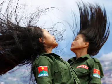 Dua prajurit wanita Tentara Negara Persatuan WA saat menari dalam sebuah acara di Pansang, wilayah pemberontak Wa di Myanmar pada 1 Oktober 2016. Kelompok Wa merupakan pemberontak yang paling kuat di Myanmar. (Reuters/Soe Zeya Tun)