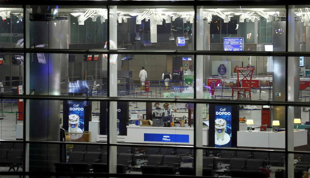 Petugas forensik berjalan di Bandara Atarturk, Istanbul, Turki, yang dihantam ledakan bom, Selasa (28/6). Bom bunuh diri tersebut setidaknya menewaskan 36 orang dan hampir 150 lainnya terluka. (REUTERS/Osman Orsal)
