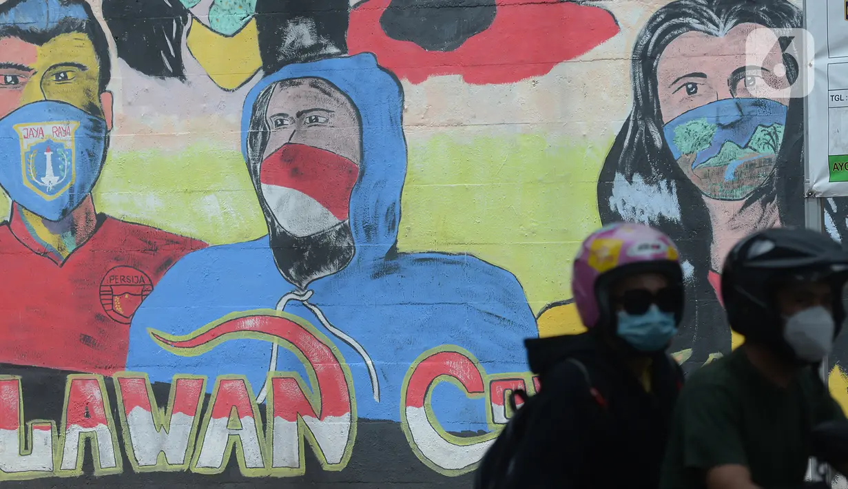 Pengendara motor melewati  mural anjuran kebiasan hidup baru dengan 3 M di Stasiun Cawang, Jakarta, Sabtu (26/12/2020). Pemerintah terus berupaya melakukan imbauan kepada warga untuk melaksanakan kebiasaan baru 3M guna memutus penyebaran virus corona (COVID-19). (merdeka.com/Imam Buhori)