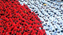 Anggota polisi membentuk formasi merah putih saat pengibaran Bendera Merah Putih terpanjang di Pantai Pandawa, Badung, Bali, Senin (14/8). Kegiatan itu memecahkan rekor MURI sebagai pembentangan Merah Putih terpanjang di tebing (AP Photo/Firdia Lisnawati)