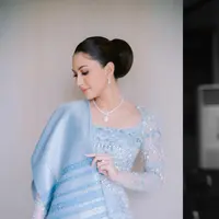 Berbeda lagi ketika Jessica Mila menjalani prosesi pertunangan khas adat Batak. Kali ini, ia memilih kebaya super cantik berwarna biru terang yang lembut, dipadu kain Ulos sebagai selendang rok yang serasi. Foto: Instagram.