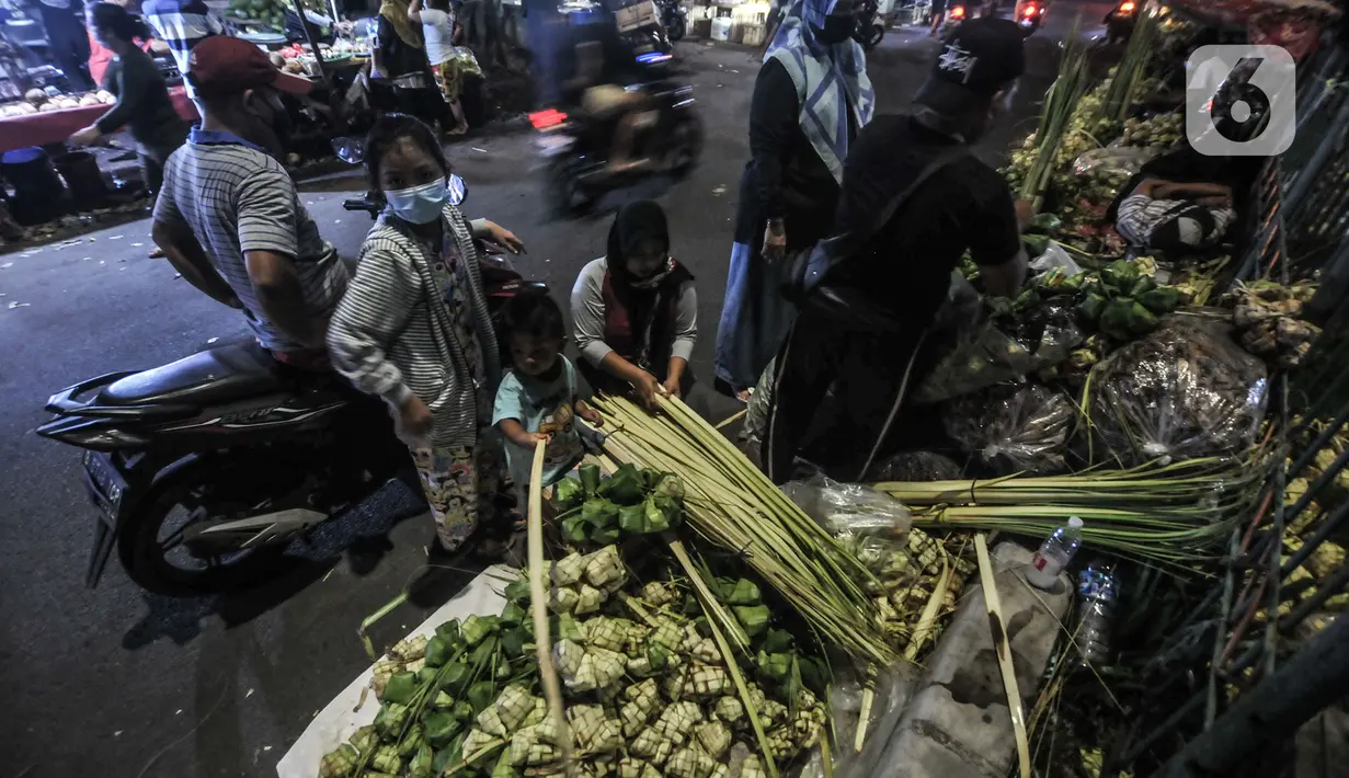 Pedagang bungkus atau tali ketupat saat melayani pembeli di Pasar Klender, Jakarta Timur, Selasa (11/5/2021) malam. Salah satu pedagang mengaku akibat pandemi corona COVID-19 penjualan ketupat menurun hingga 70 persen. (merdeka.com/Iqbal S Nugroho)