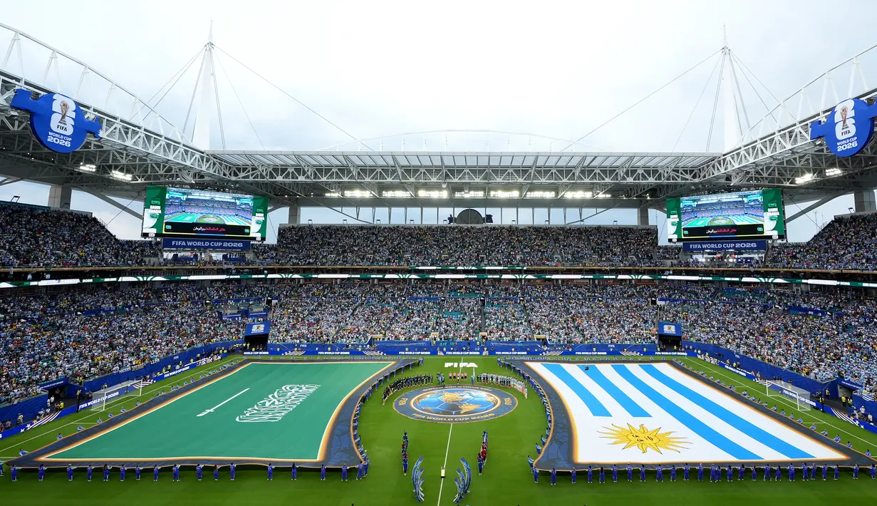 Para volunteer tetap mengangkat bendera tersebut selama seremoni tersebut berlangsung. Hal tersebut juga membuat bendera lawan, Uruguay juga sama perlakuannya untuk membuat visual yang seimbang. (AP Photo/Marta Lavandier)
