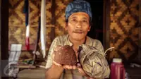 Seorang warga Baduy Luar menunjukan gula aren yang dibungkus daun dan telah dibuka untuk siap dikonsumsi di Kampung Kadu Jangkung, Kabupaten Lebak, Banten (12/05). Gula aren tersebut digunakan sebagai dasar pembuatan makanan. (Liputan6.com/Fery Pradolo)