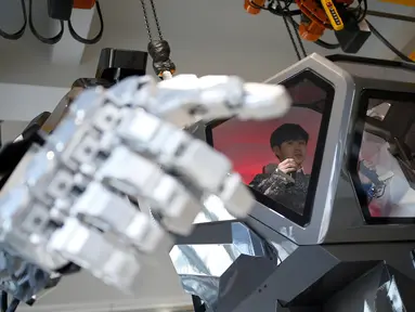 Seorang karyawan berada di dalam ruang kontrol mengerakan tangan robot berawak  "METHOD-2" selama demonstrasi di Gunpo, Korea Selatan, (27/12). Robot raksasa ini memiliki ketinggian 4 meter. (Reuters/Kim Hong-Ji)