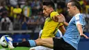 Pemain timnas Ekuador, Angel Mena berebut bola dengan pemain timnas Uruguay, Diego Laxalt dalam laga pertama Grup C Copa America 2019 di Stadion Mineirao, Brasil, Minggu (16/6/2019). Uruguay berhasil memetik kemenangan besar 4-0 atas Ekuador. (Luis ACOSTA / AFP)