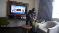 Pegawai melakukan penyemprotan disinfektan di kamar Hotel Grand Whiz Poins Simatupang, Jakarta, Kamis (16/4/2020). Di tengah pandemi virus corona COVID-19, hotel ini menyediakan paket isolasi mandiri selama 14 hari dengan harga Rp 6.500.000. (merdeka.com/Dwi Narwoko)