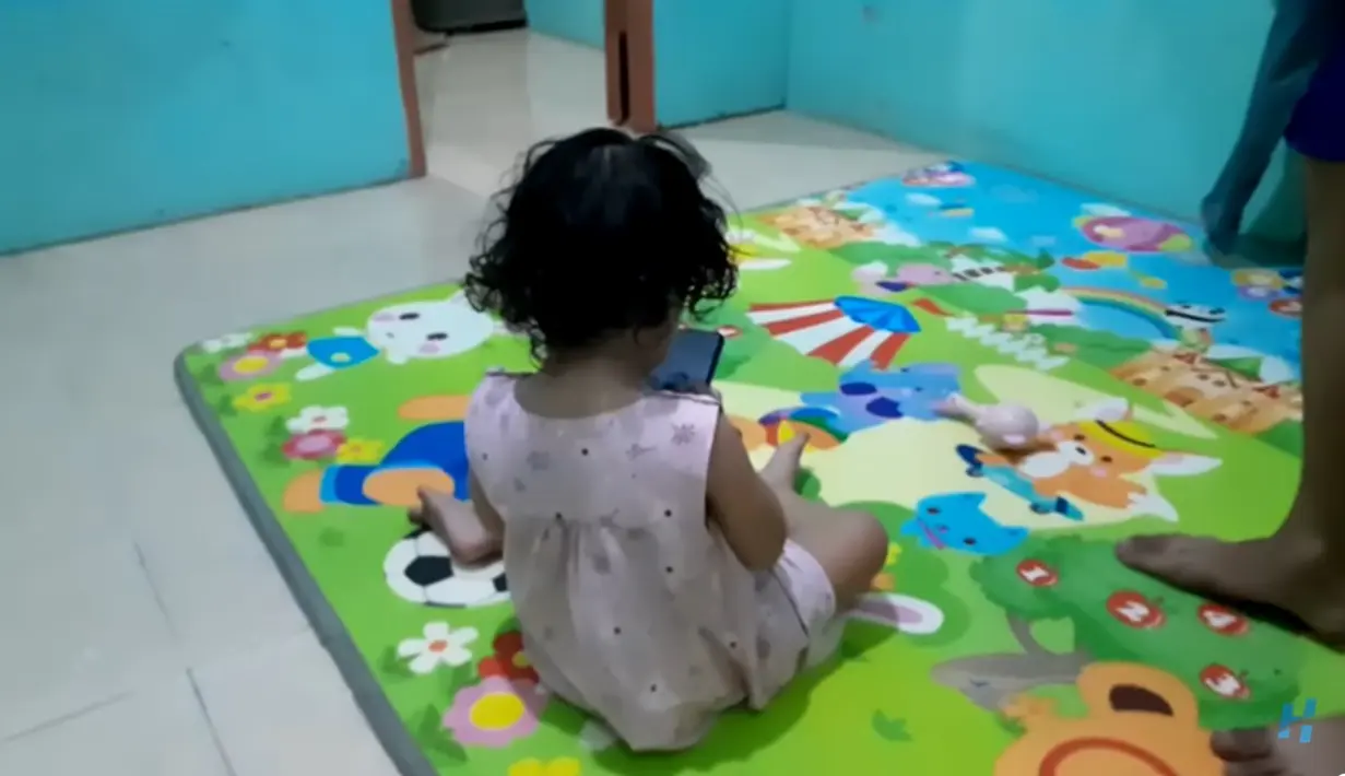Rumah Sidik tampak tidak banyak parabot. Dengan dinding warna biru telor asin. Anak pertama Sidik tampak sedang mainan di atas tikar. [Youtube/HepiNews]