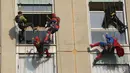 Sejumlah orang berpakaian superhero turun dari atap untuk memberi kejutan di jendela kamar pasien anak di bangsal Pediatri rumah sakit San Paolo di Milan, Italia, Rabu (15/12/2021). Aksi Spiderman dkk itu untuk menghibur anak-anak yang dirawat di rumah sakit tersebut. (AP Photo/Luca Bruno)
