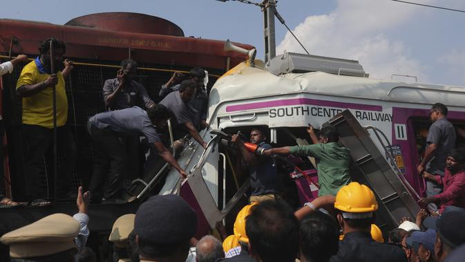 Petugas berusaha menyelematkan seorang pekerja di kabin kereta api surburban setelah bertabrakan dengan kereta ekspres antarkota di Stasiun Kereta Api Kachiguda di Hyderabad, India (11/9/2019). Sekitar 12 orang terluka akibat kecelakaan tersebut. (AP Photo/Mahesh Kumar A.)