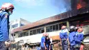 Petugas pemadam kebakaran berusaha memadamkan api yang membakar ruko di kompleks Kanjengan, Pasar Johar Semarang, Sabtu (18/6). Dugaan awal, kebakaran tersebut diakibatkan hubungan pendek arus listrik di salah satu toko di Blok E. (Liputan6.com/Gholib)