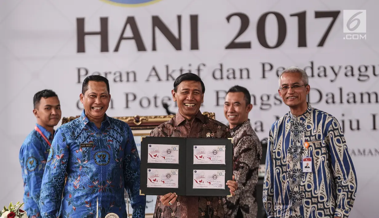 Menko Polhukam Wiranto (tengah) menunjukan prangko edisi HANI 2017 dalam puncak peringatan Hari Anti-Narkoba Internasional (HANI) di Plaza Tugu Api Pancasila, Taman Mini Indonesia Indah, Jakarta, Kamis (13/7). (Liputan6.com/Faizal Fanani)