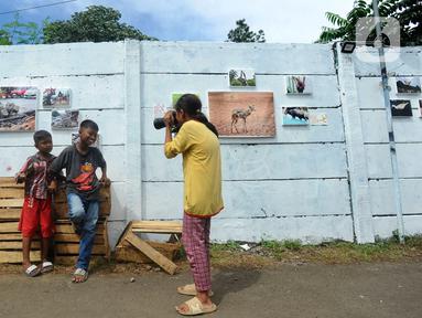 Anak-anak belajar memotret dengan kamera DSLR saat kegiatan pameran Lensa Anak Terminal di Sekolah Master, Depok, Jawa Barat, Rabu  (8/2/2023). Pameran 170 karya foto dari 12 anak-anak terminal di kawasan tersebut merupakan hasil pembelajaran bersama Komunitas Lensa Anak Terminal dan berlangsung  hingga 12 Februari 2023. (merdeka.com/Arie Basuki)