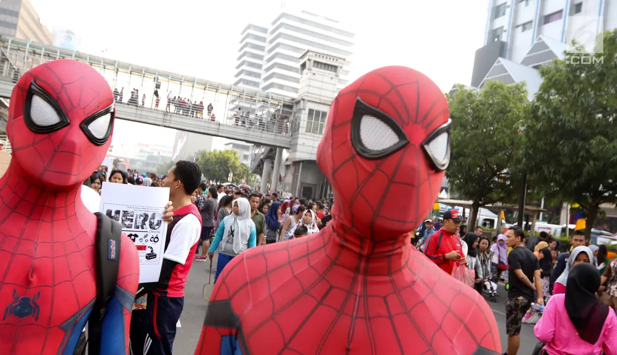Dua orang dengan kostum Spiderman menunggu warga untuk berswafoto di CFD Jalan MH Thamrin, Jakarta, Minggu (6/8). Kehadiran para Spiderman membuat heboh warga. (Liputan6.com/Fery Pradolo)