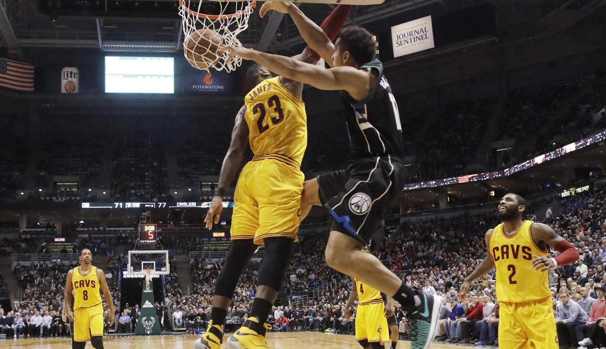 Pemain Milwaukee Bucks, Malcolm Brogdon melakukan dunks melewati hadangan pemain Cleveland Cavaliers, LeBron James (23) pada laga NBA di BMO Harris Bradley Center, (20/12/2016). Cavs menang 114-108.  (AP/Morry Gash)
