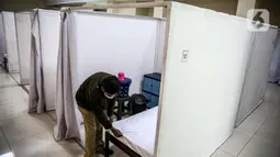 Petugas bersiap masuk ke bilik disinfektan ruang isolasi mandiri pasien COVID-19 di Gelanggang Remaja Kecamatan Pademangan, Jakarta, Senin (28/9/2020). Sebanyak 30 bilik isolasi pasien Covid-19 disediakan dengan fasilitas tempat tidur, lemari, dan peralatan mandi. (Liputan6.com/Faizal Fanani)