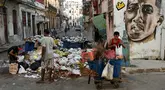 Warga Kuba mengumpulkan bahan mentah dari sejumlah besar sampah di sebuah jalan di Havana pada 23 Agustus 2024. (YAMIL LAGE / AFP)