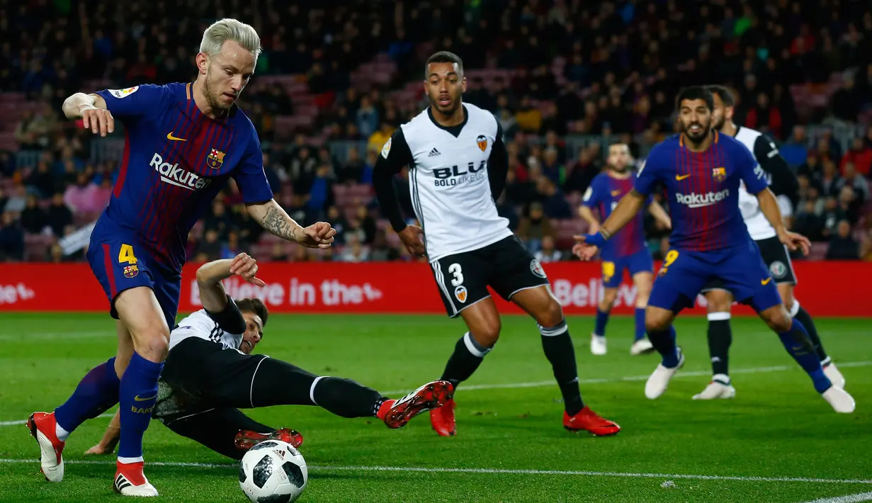 Pemain Barcelona, Ivan Rakitic merebut bola dari pemain Valencia pada semifinal pertama Copa del Rey di Stadion Camp Nou, Jumat (2/2). Menang 1-0 atas Valencia, peluang Barcelona untuk melaju ke partai final terbuka lebar. (AP/Manu Fernandez)