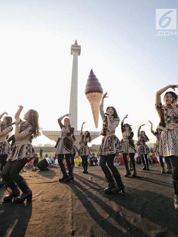 Girlband JKT48 saat tampil dalam acara puncak Kirab Obor Asian Games 2018 di Monas, Jakarta, Sabtu (18/8). Obor Asian Games 2018 diarak dari Monumen Nasional (Monas) menuju Stadion Utama Gelora Bung Karno (SUGBK). (Liputan6.com/Faizal Fanani)