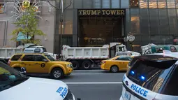 Departemen Kepolisian New York menempatkan sejumlah truk berisi pasir menutupi bagian depan Gedung Trump Tower, Selasa (8/11). Menurut sumber, truk-truk pasir itu berguna melindungi bangunan tersebut dari penyerangan mendadak. (BRYAN R. SMITH/US-VOTE/AFP)