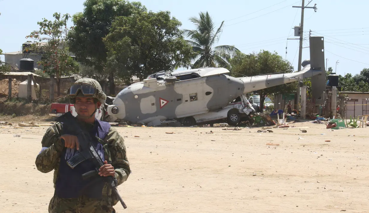 Tentara berjaga dekat helikopter milter UH-60 Black Hawk yang jatuh di Santiago Jamiltepec, negara bagian Oaxaca, Meksiko, Sabtu (17/2). Helikopter itu berada di Oaxaca untuk melihat kerusakan akibat gempa 7,5 SR. (AP/Luis Alberto Cruz Hernandez)